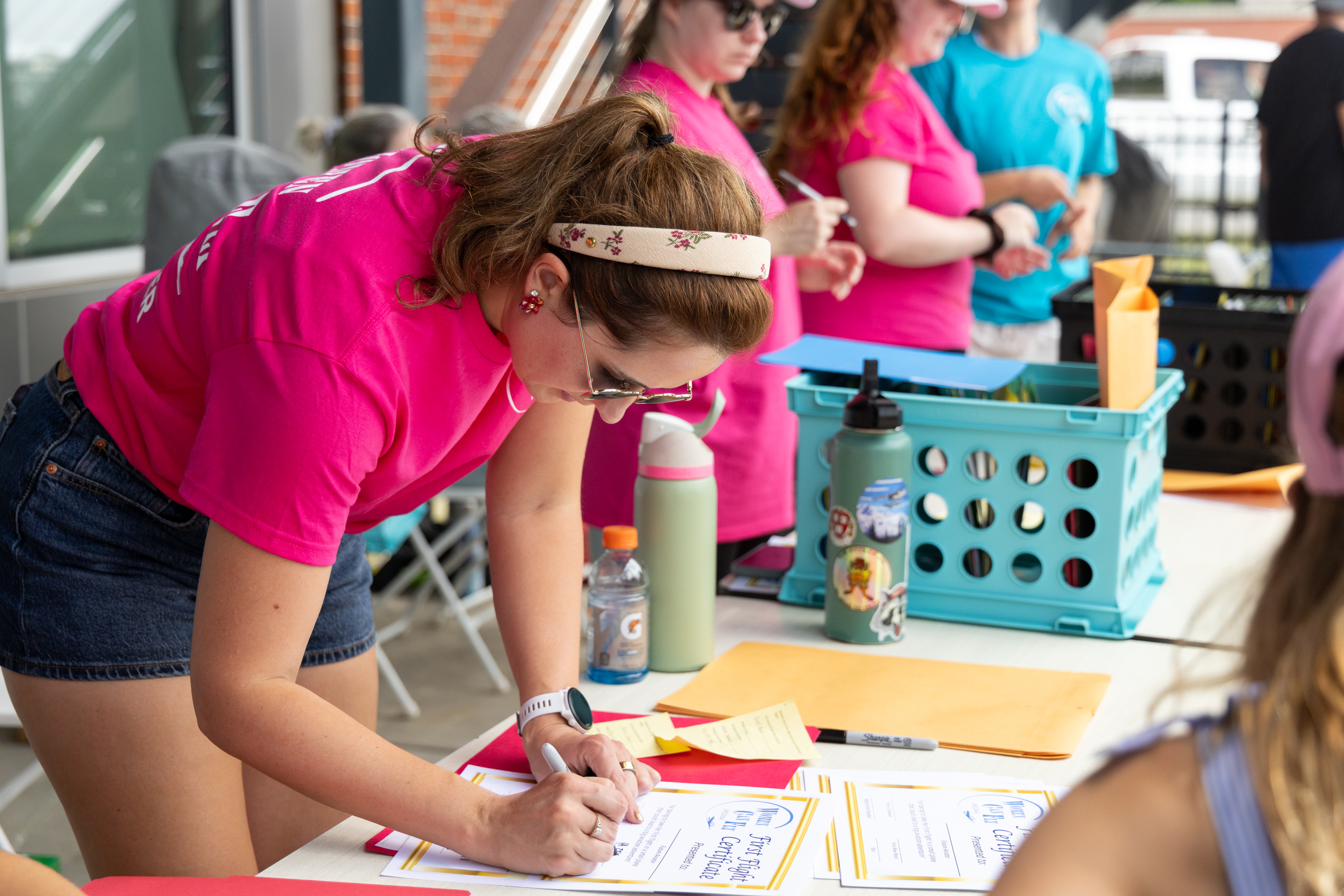 A volunteer prepares first flight certificates to be given to attendees after they land. Photo by Rebecca Boone.