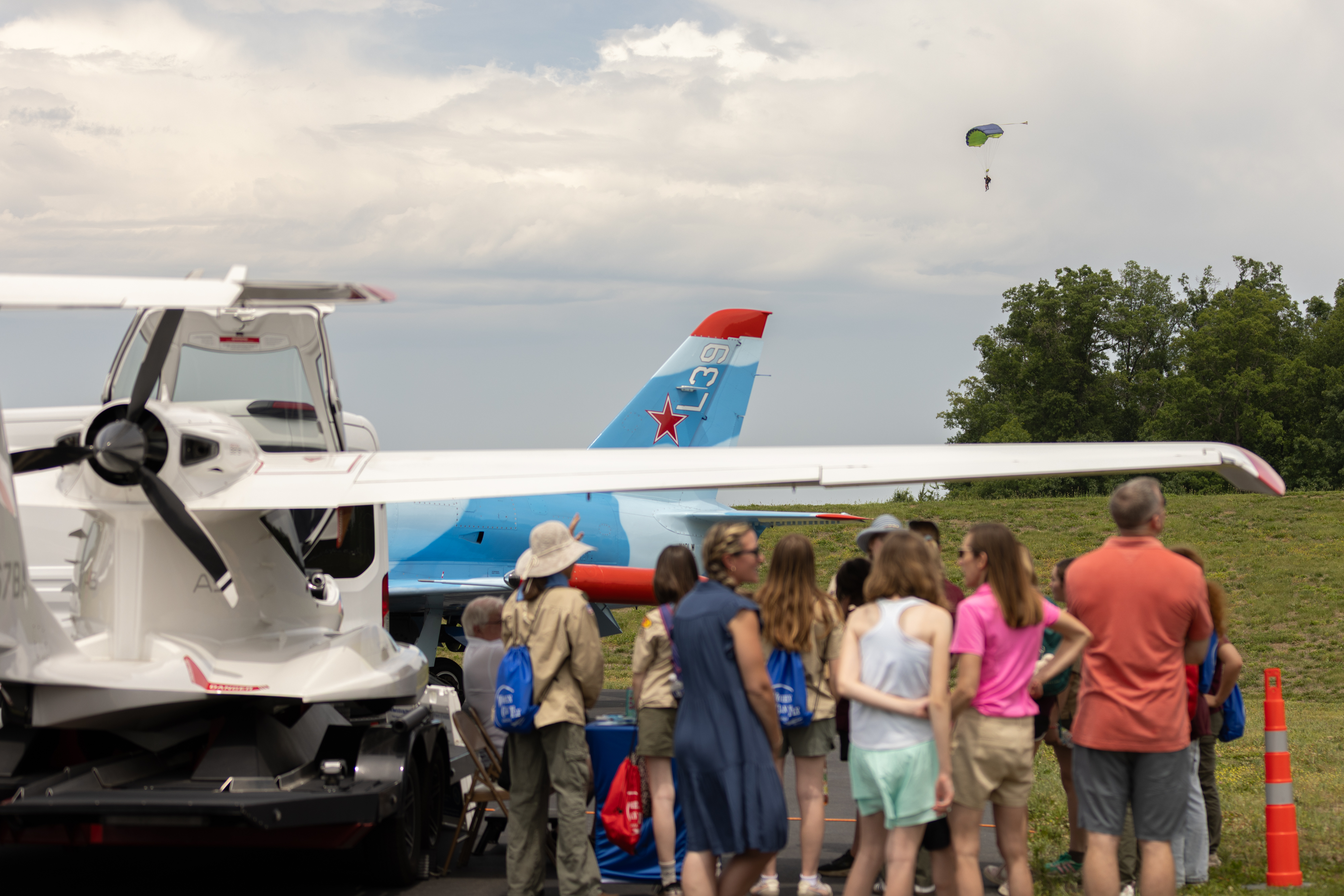 Attendees gather in the static display area as a parachutist lands nearby. Photo by Rebecca Boone.