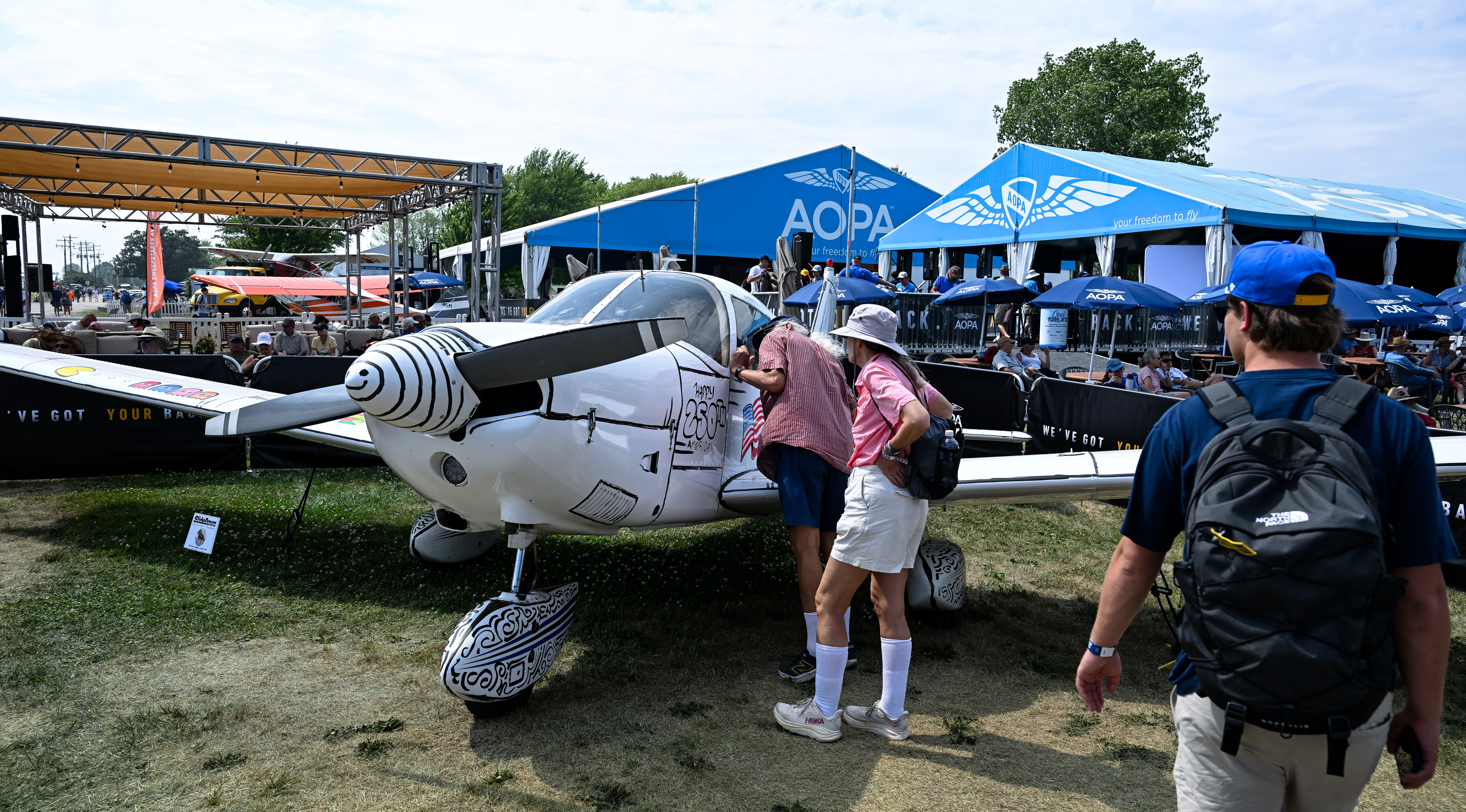 Visitors look at the new AOPA Sweepstakes Piper Archer. Photo by David Tulis.