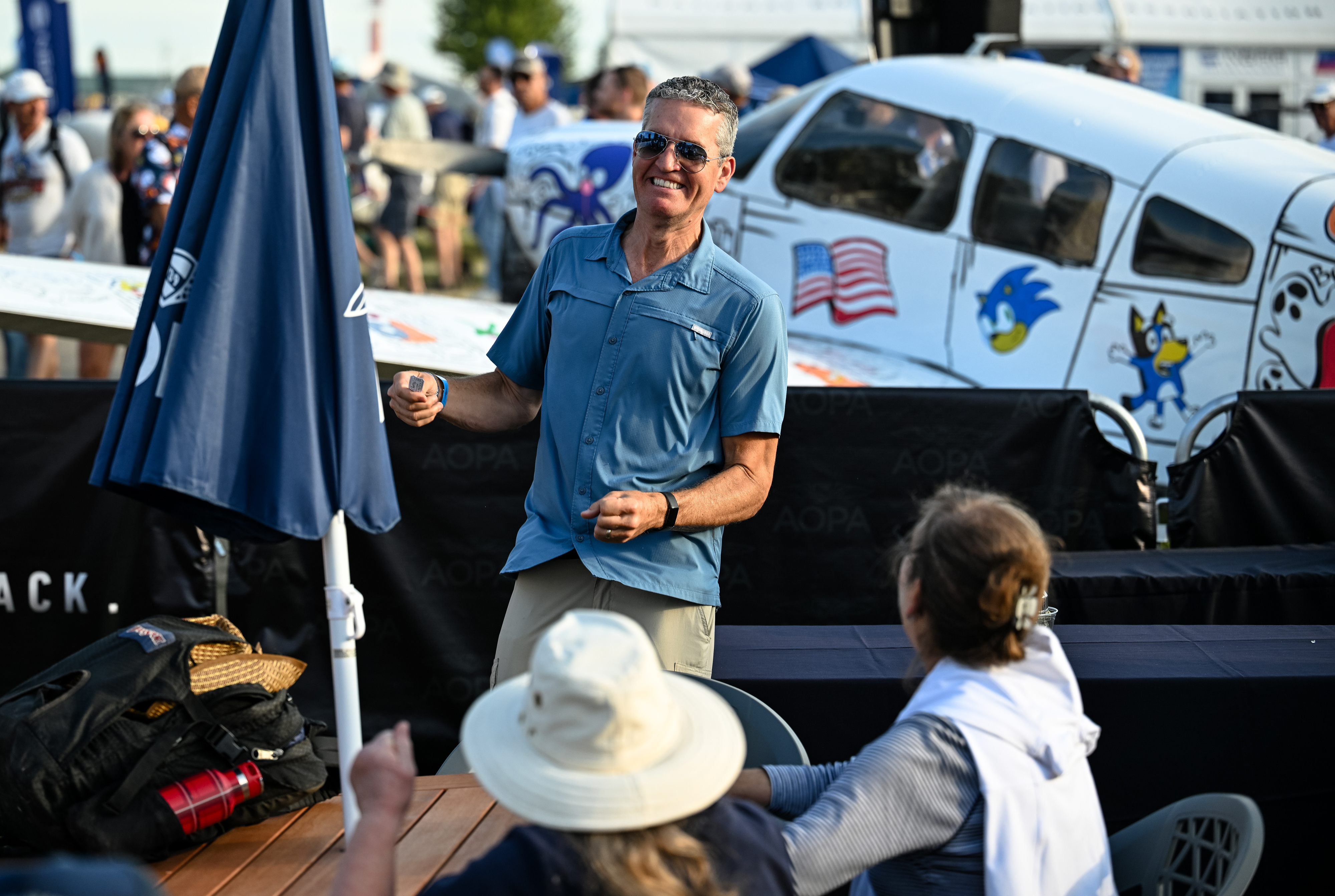 AOPA members socialize near the AOPA Sweepstakes Piper Archer. Photo by David Tulis.