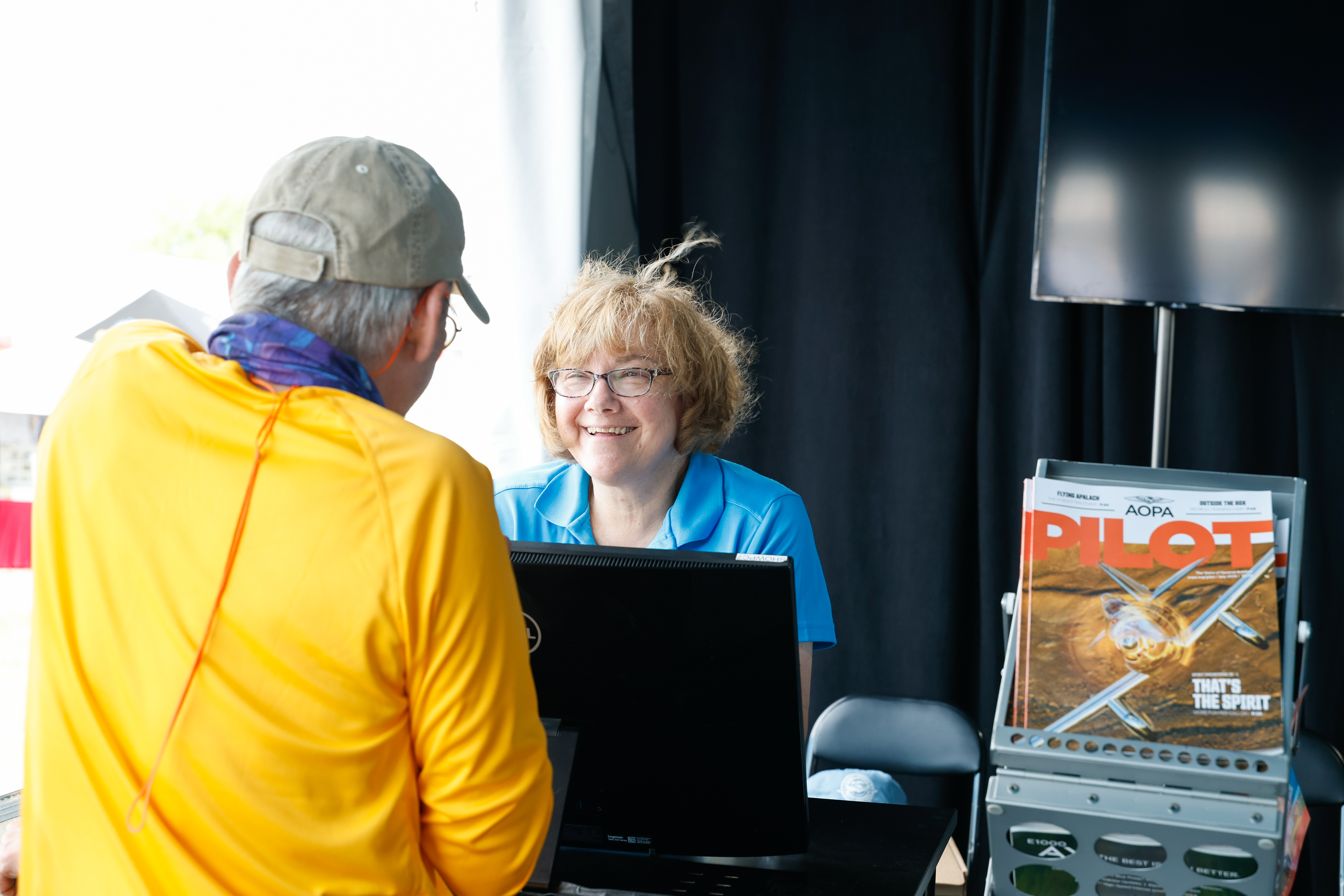 AOPA Member Services Senior Specialist Gayle Fabricatore shares a laugh with a member. Photo by Chris Rose.