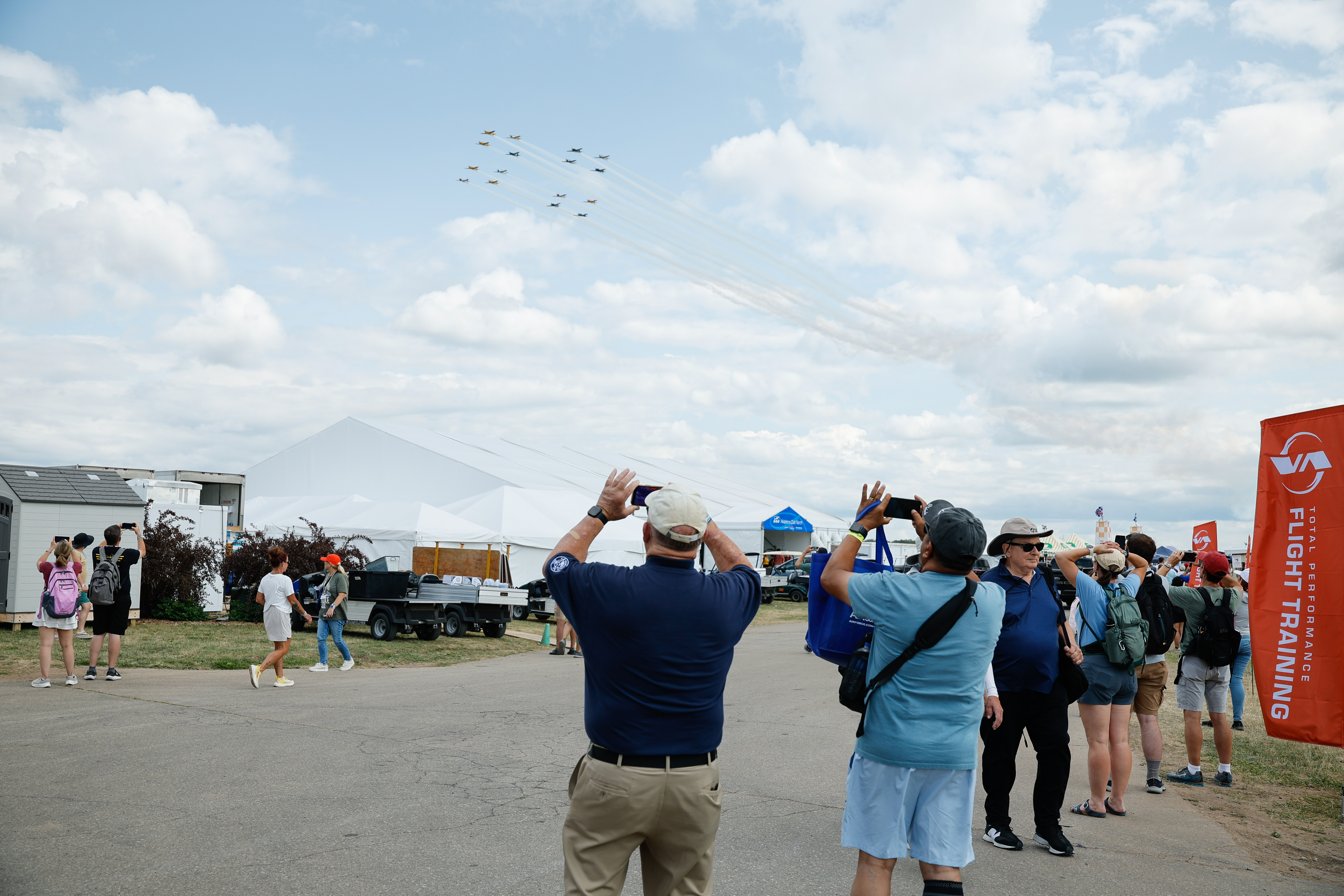 Attendees record the aircraft flying overhead. Photo by Chris Rose.
