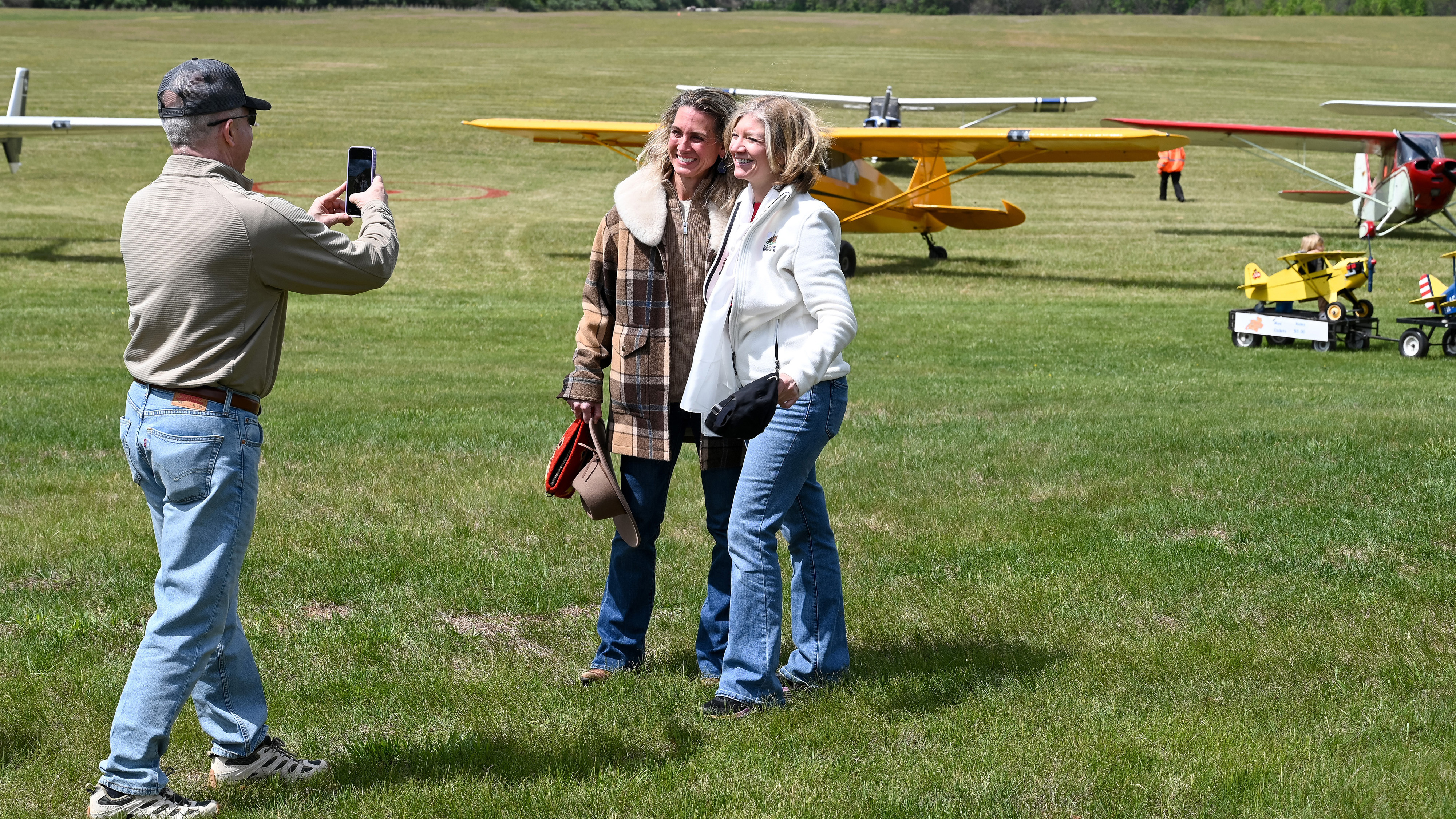 Retired U.S. Air Force pilot, charter pilot, and general aviation pilot Heather "Lucky" Penney, left, and retired airline captain, author of "Jet Boss," chairman of the Virgina Chapter of The Ninety-Nines, and GA pilot Laura Savino, right, pose for a picture at a fly-in to the Horse Feathers grass airstrip. Photo by David Tulis.