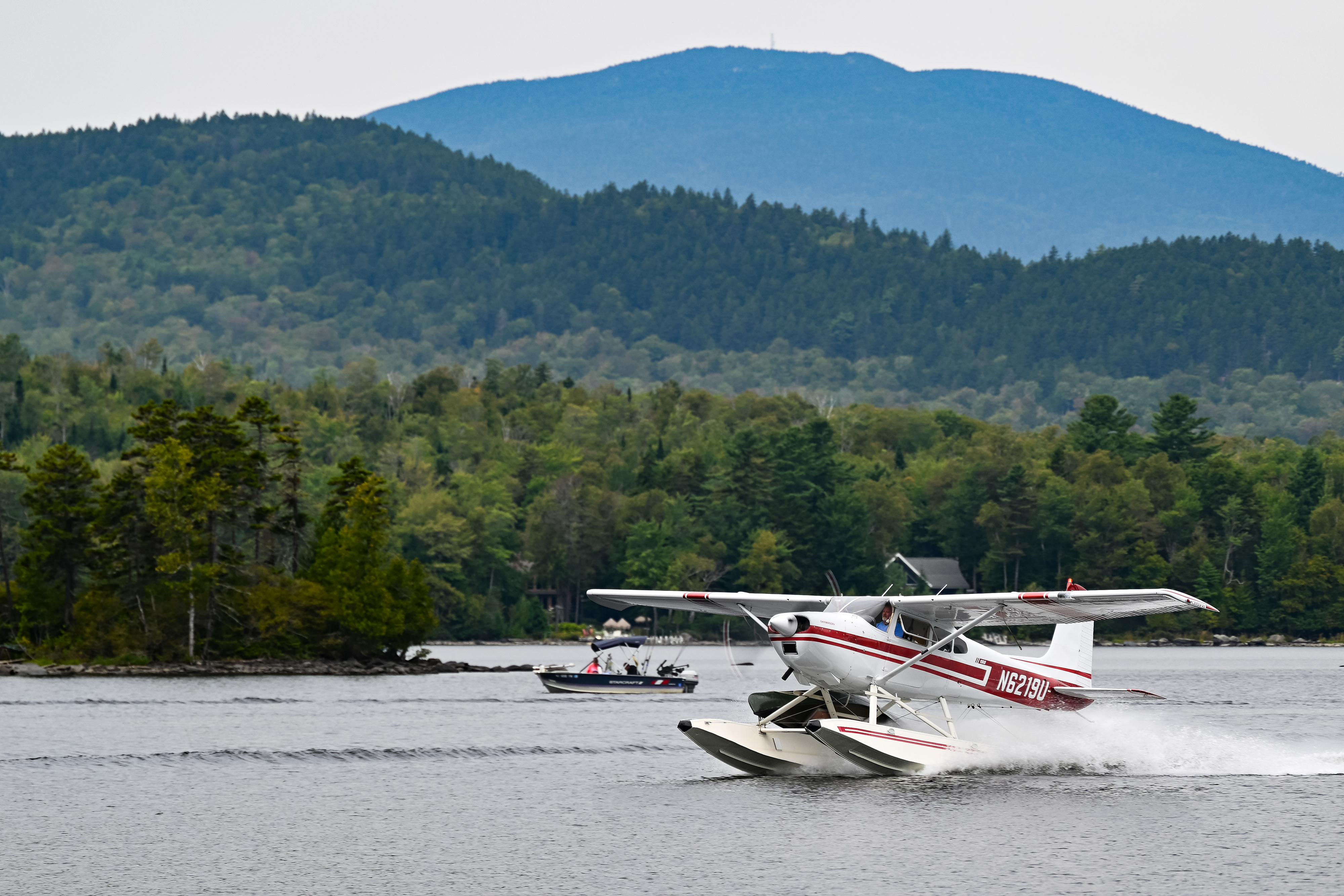 Jeff Hardy step-taxis his 1969 Cessna 180 toward the finish line dock where teammate and niece Baily Cust will unlash the canoe tied to his strut. Photo by David Tulis.