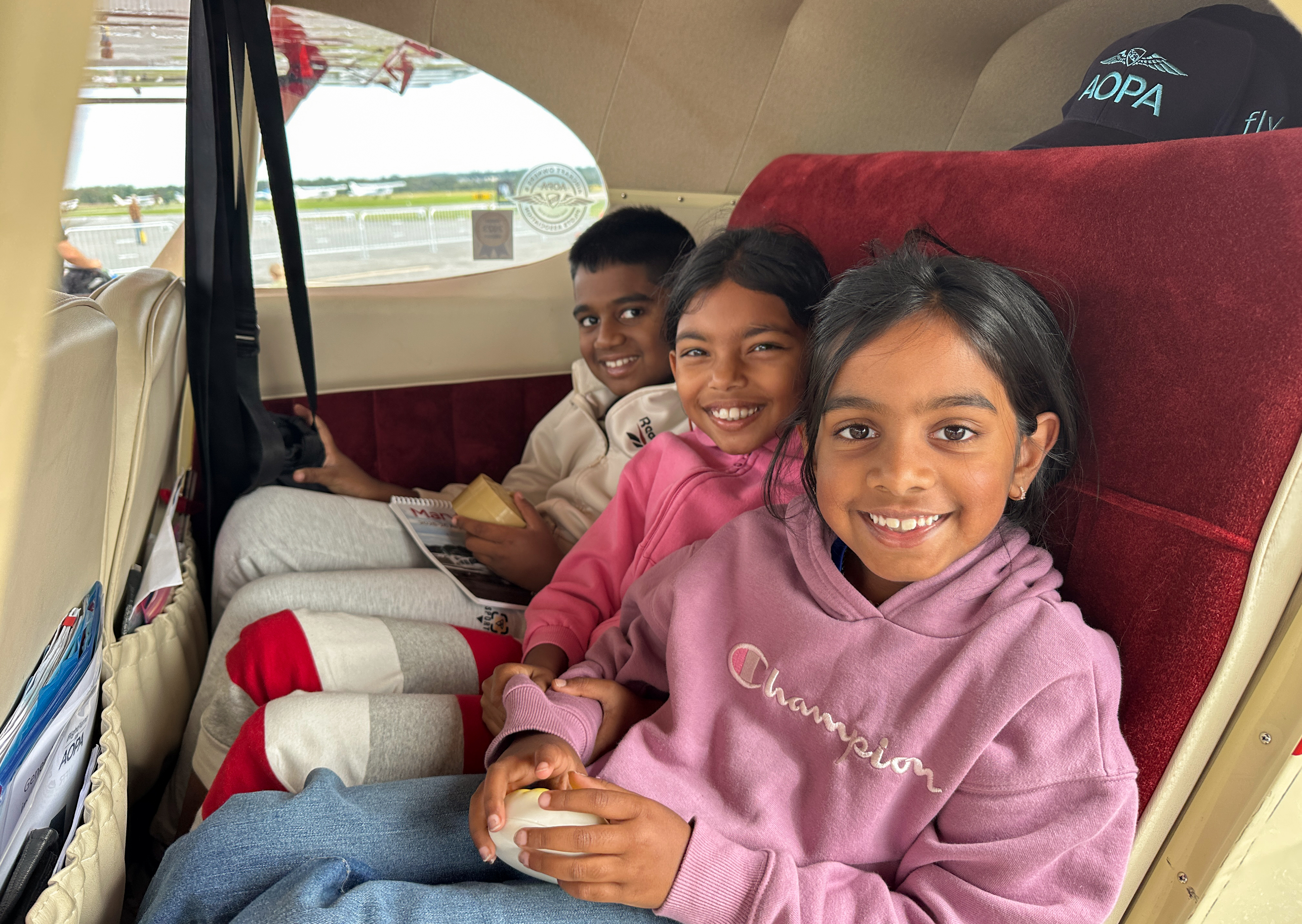 Children experience general aviation from the back seat of a vintage Piper Tri-Pacer. Photo by David Tulis.