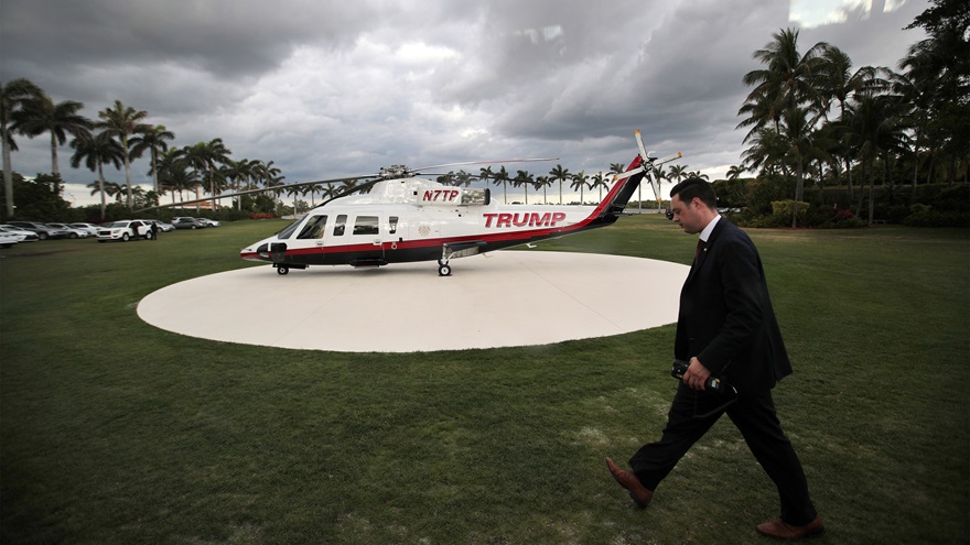A member of the U.S. secret service walks by President Donald Trump's personal helicopter at Mar-a-Lago estate in Palm Beach, Florida, April 9, 2017. Photo by Carlos Barria, REUTERS.