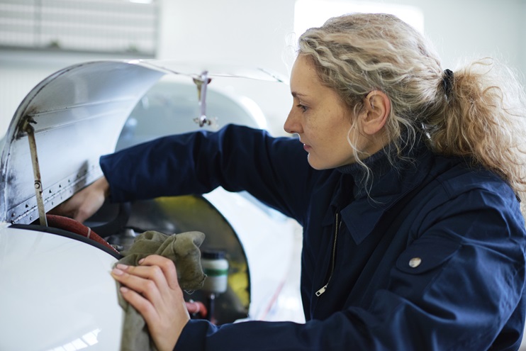 A female aviation technician works on an engine. iStock photo.   