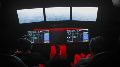 The 42 networked flight simulators are a highlight of the National Flight Academy programs. Within the four-story, multi-deck facility are scenically and theatrically designed work areas that encourage immersive role playing. A graduation ceremony caps off the weeklong summer camp deployment.