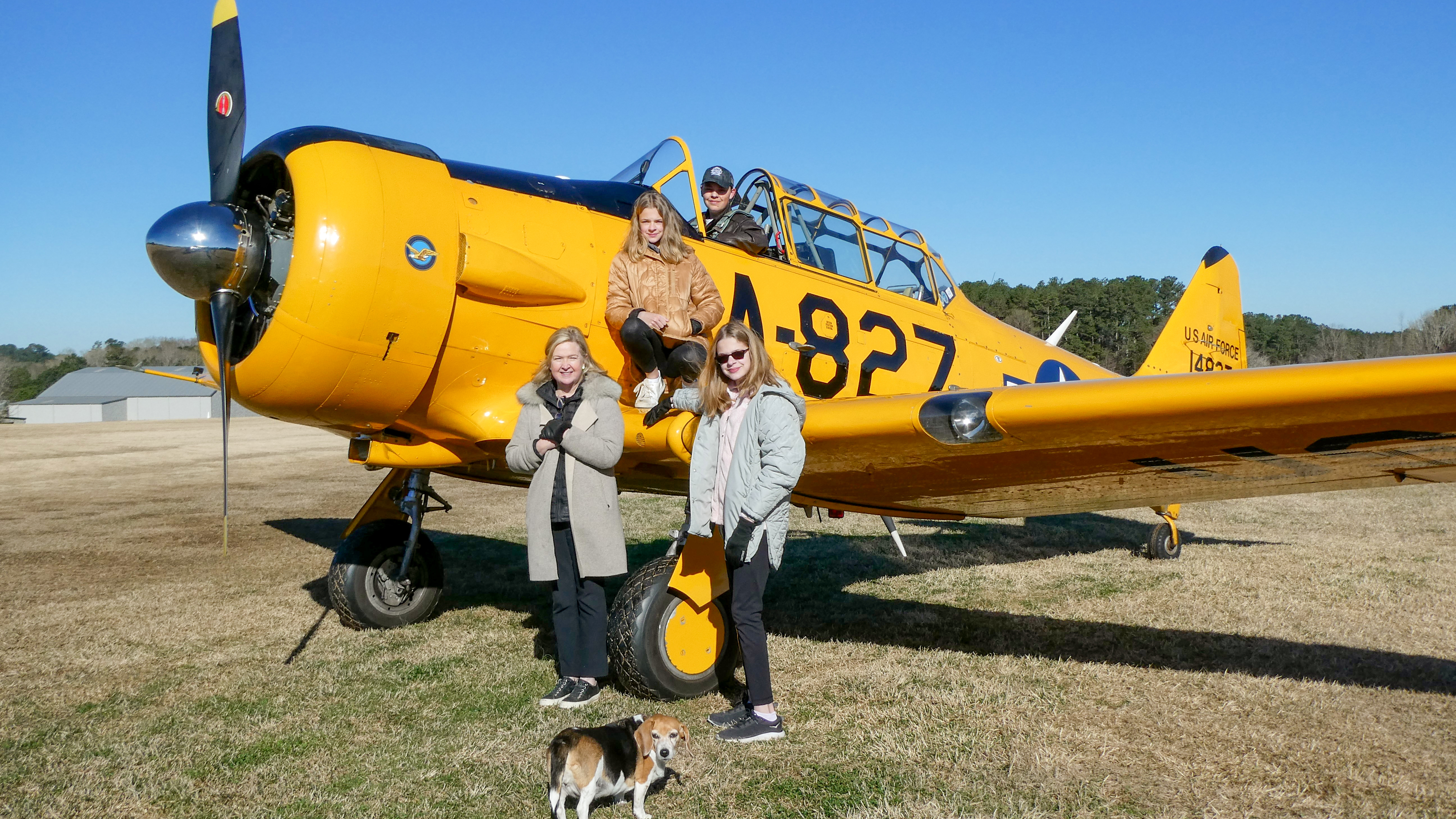 James Frank soloed a North American T–6 Texan on his sixteenth birthday. He is pictured with his mother and sisters immediately following his victorious flight.