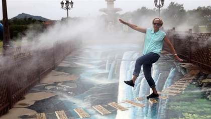 No, she won’t fall off. Sylvia Horne at the Art and Alive Museum, walking on a very unidimensional trompe l’oeil painting.