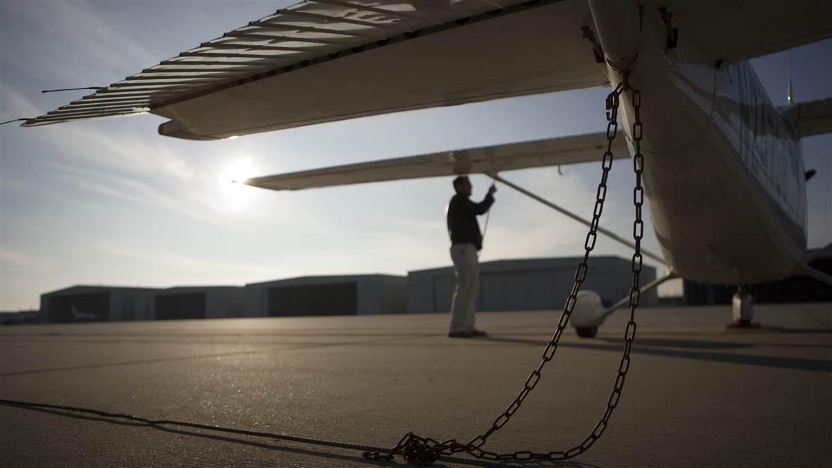 Tie down chains with pilot in background.