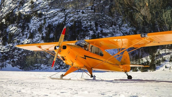 A Piper PA–12 is exceptionally light but with straight skis is limited to snow surfaces for takeoffs and landings.