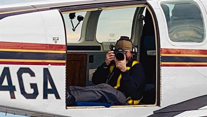 Rose sits on a foam dog bed in the open door of a Bonanza A36—an extremely versatile photo ship because of its removable doors and broad speed range. (Shinji Maeda)
