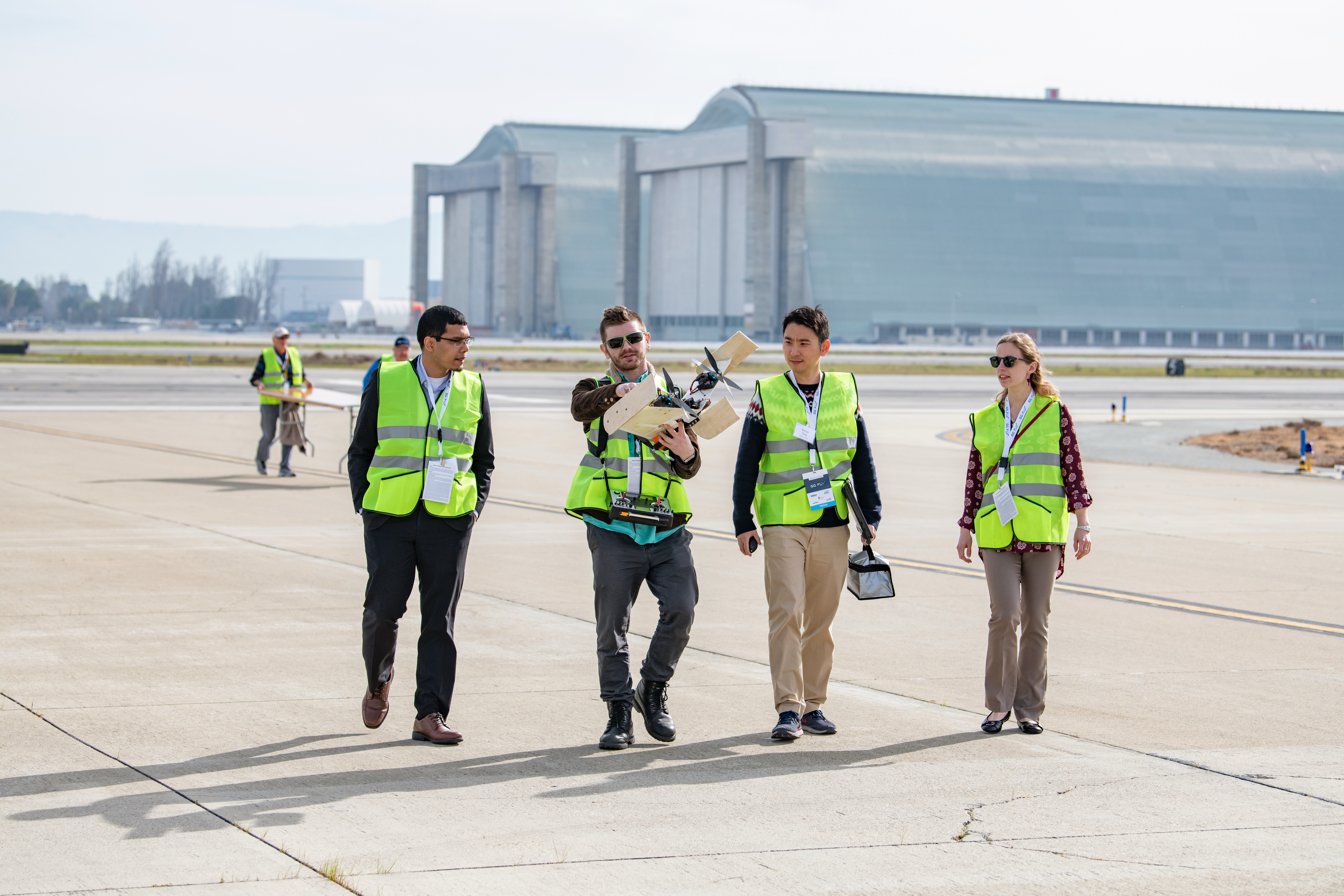 Ben Sena (second from left, above) and Soojae Jung (third from left) of Team Jayu carry a scale model of their design after a demonstration flight at Moffett Federal Airfield.