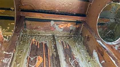 Inside the widgeon's right wing, the remnants of poorly applied orange fuel tank sealant are everywhere. Repairing the tanks meant laboriously scraping away all the old sealant and applying a gooey new kind, then pressurizing the tanks. After several weeks of difficult work, the new tanks are holding.