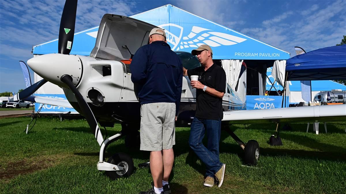 AOPA Vice President of Publications/Editor Kollin Stagnito explains modifications performed on the AOPA Sweepstakes Grumman Tiger during EAA AirVenture in Oshkosh, Wisconsin, July 30. Photo by David Tulis.