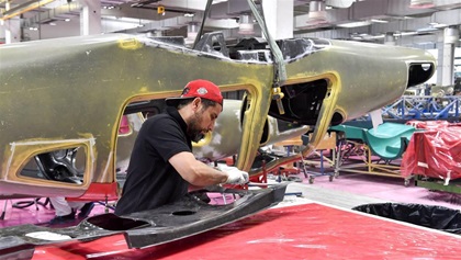 Trimming excess carbon fiber from wheel wells.