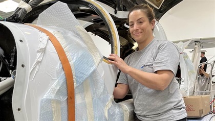 Maria Reichert strikes a “Rosie the Riveter” pose while installing avionics.