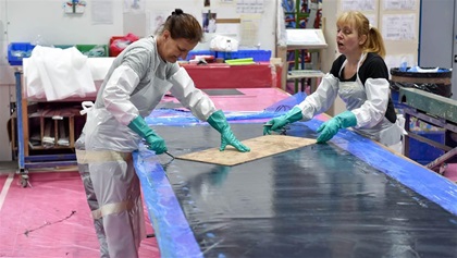 Cutting plies of carbon fiber in preparation for installing them in wing molds. For extra strength, 30 or more plies may be used to give the wing spar roots and attach points the necessary strength. At the tips, as few as three plies are needed.