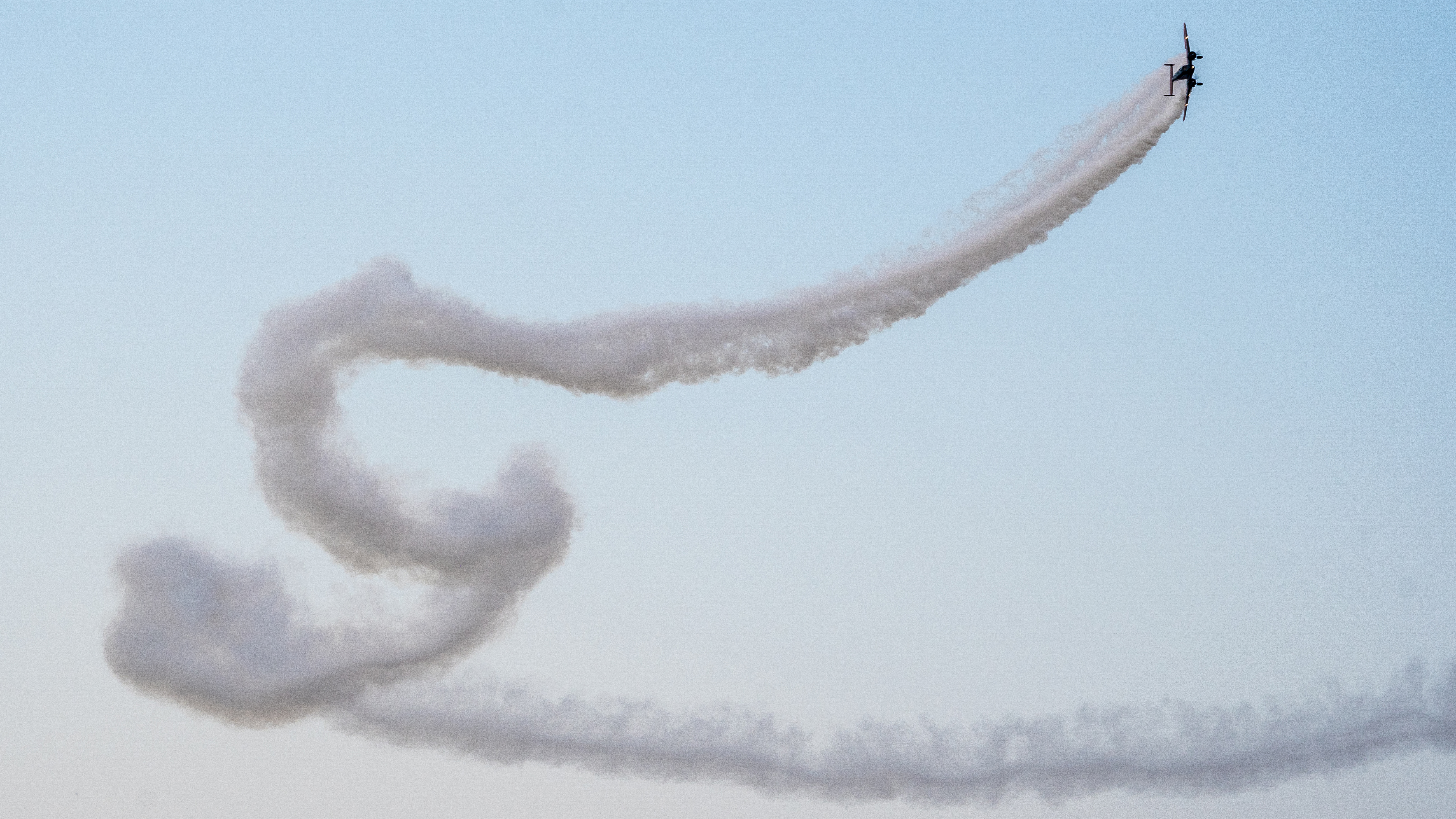 Twin Beech contrail at EAA AirVenture. "I try to see the whole image, including the sky and the background, and not just the airplane. Smoke trails make wonderful shapes that are often more interesting than the aircraft making them."