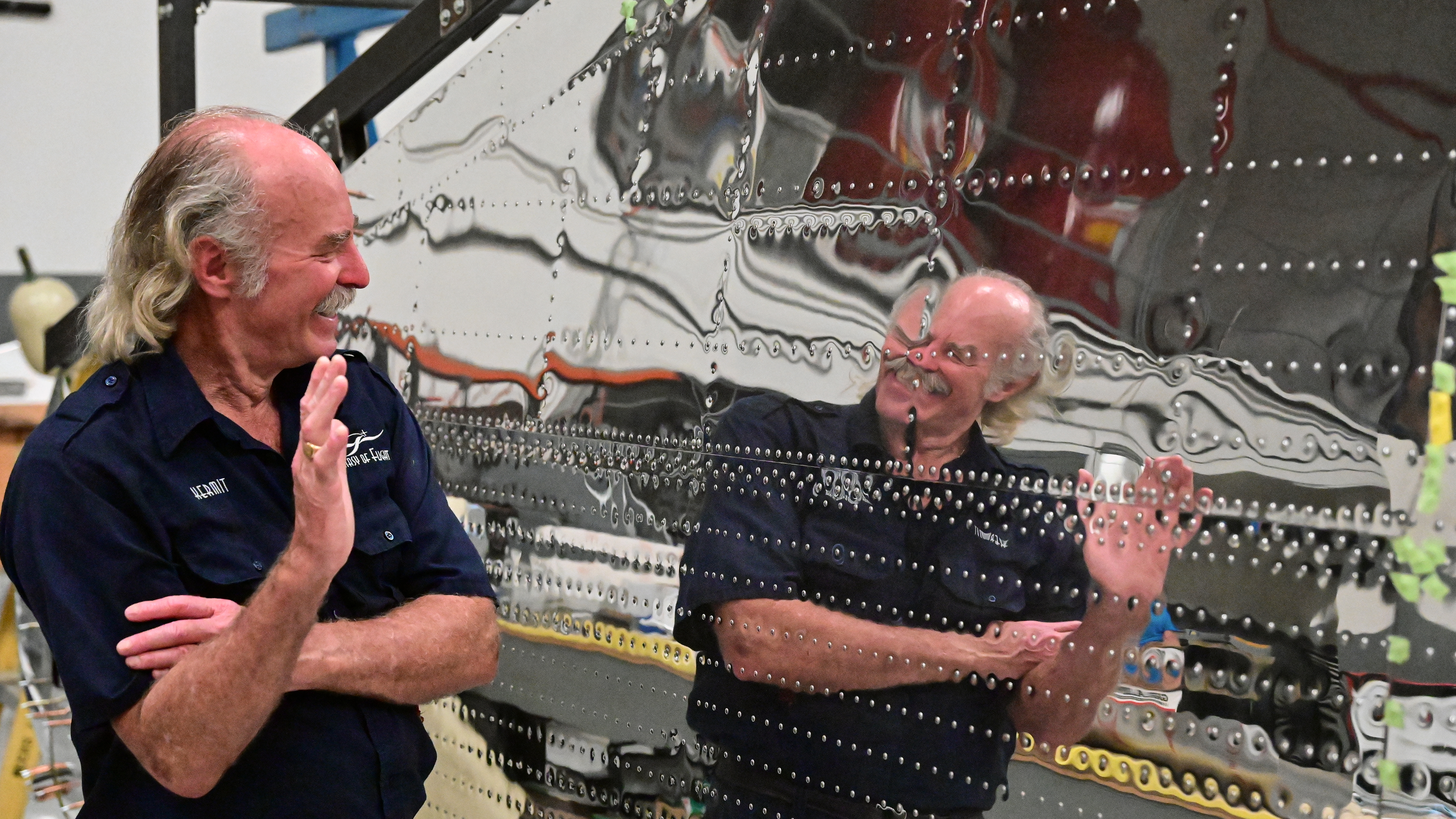 Reflections in a highly polished metal wing under restoration.