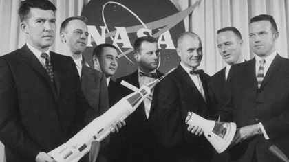 The Mercury astronauts (left to right) Schirra, Shepard, Grissom, Slayton, Glenn, Carpenter, and Cooper holding models of an Atlas rocket and a Mercury capsule. (NASA)