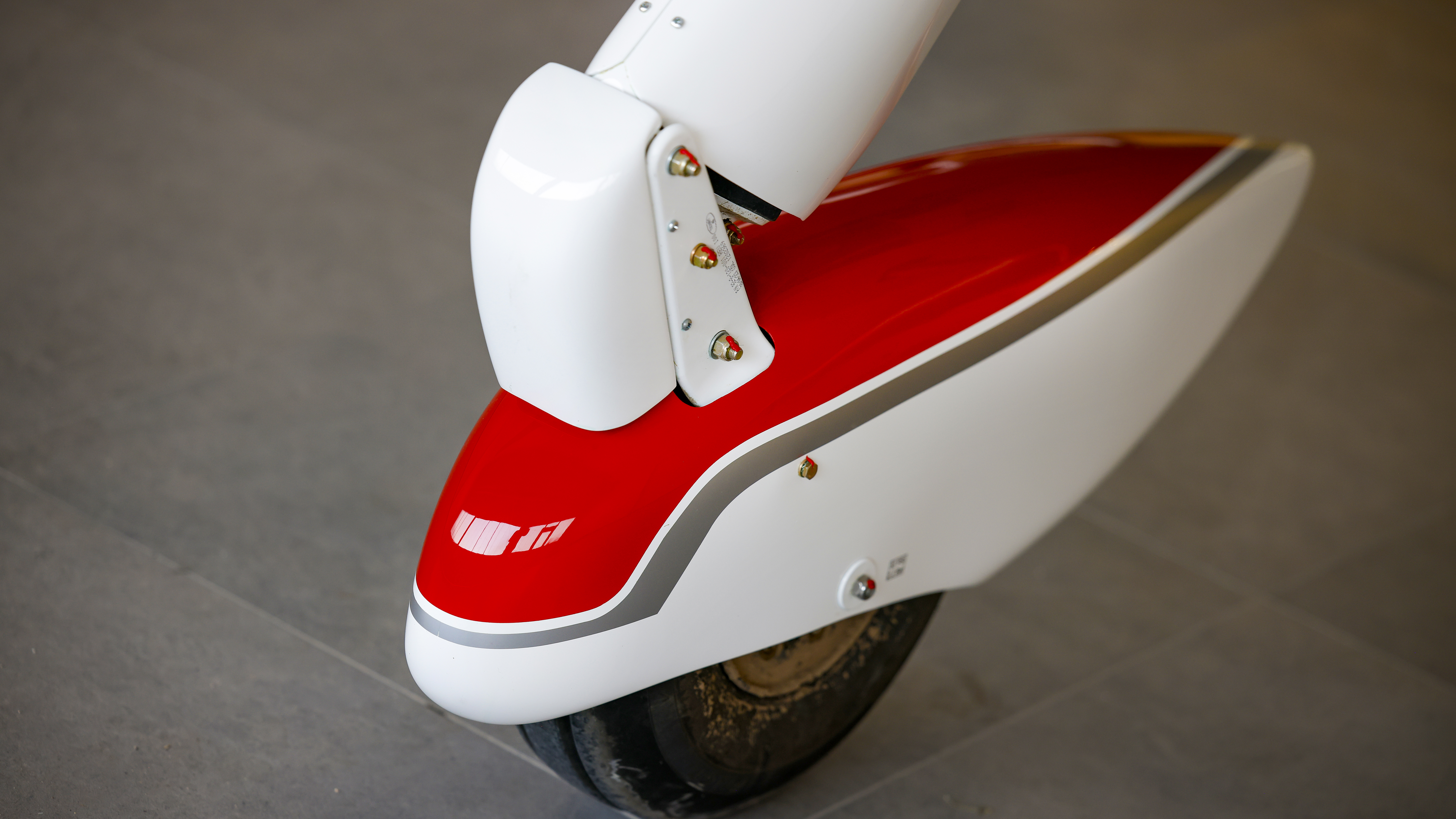 A nosewheel shock absorber is built for taking the  punishment student pilots are sure to dole out, and mud on the tire is a remnant of the grass airstrip outside the Tecnam factory. 