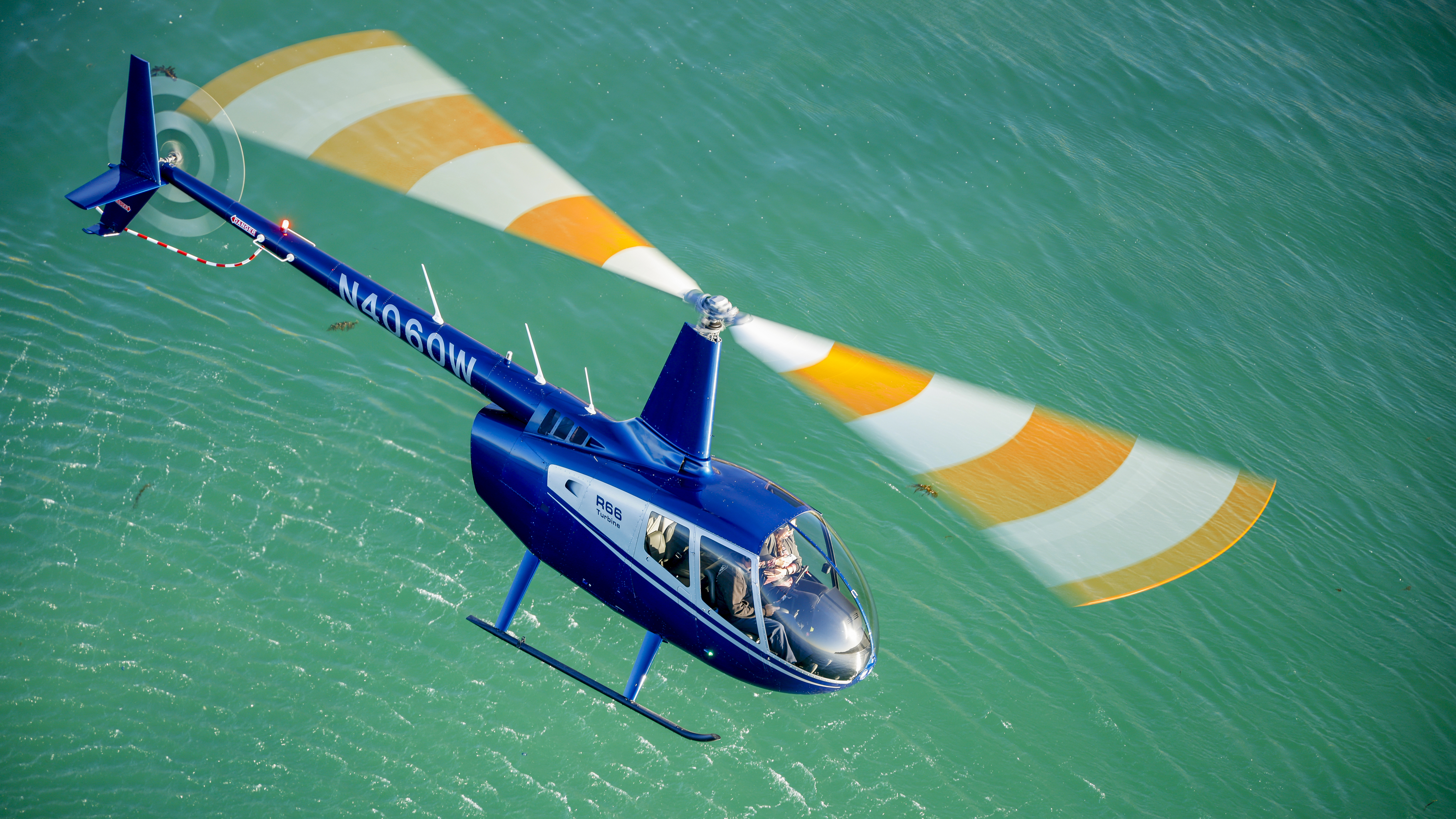 Slow flight and hover require high power settings, creating significantly disturbed air and wake turbulence, seen here in the rippling water.