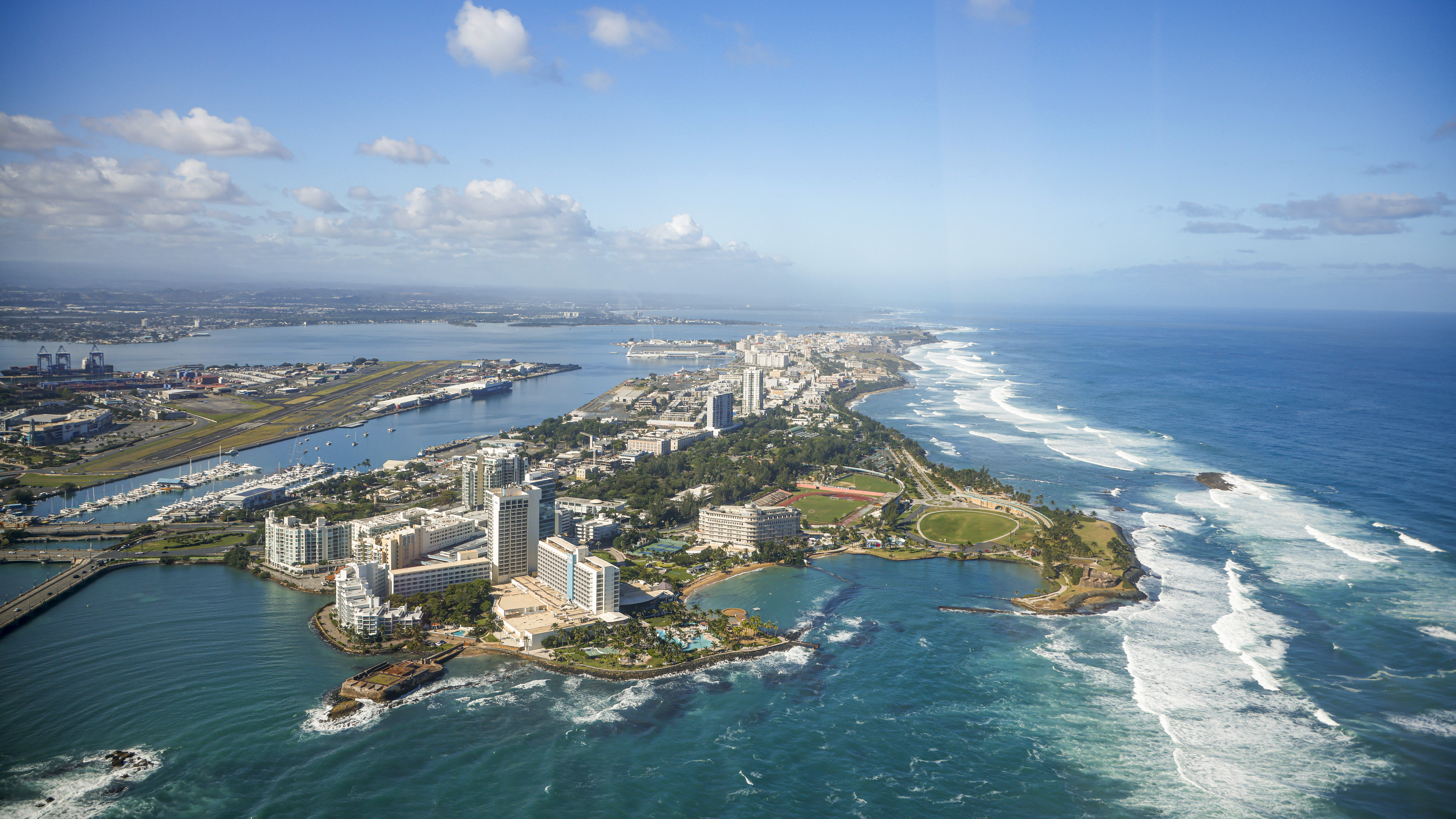 High-rise buildings on the north shore of San Juan have commanding views of the beaches and harbor. Isla Grande Airport is visible on the far left.