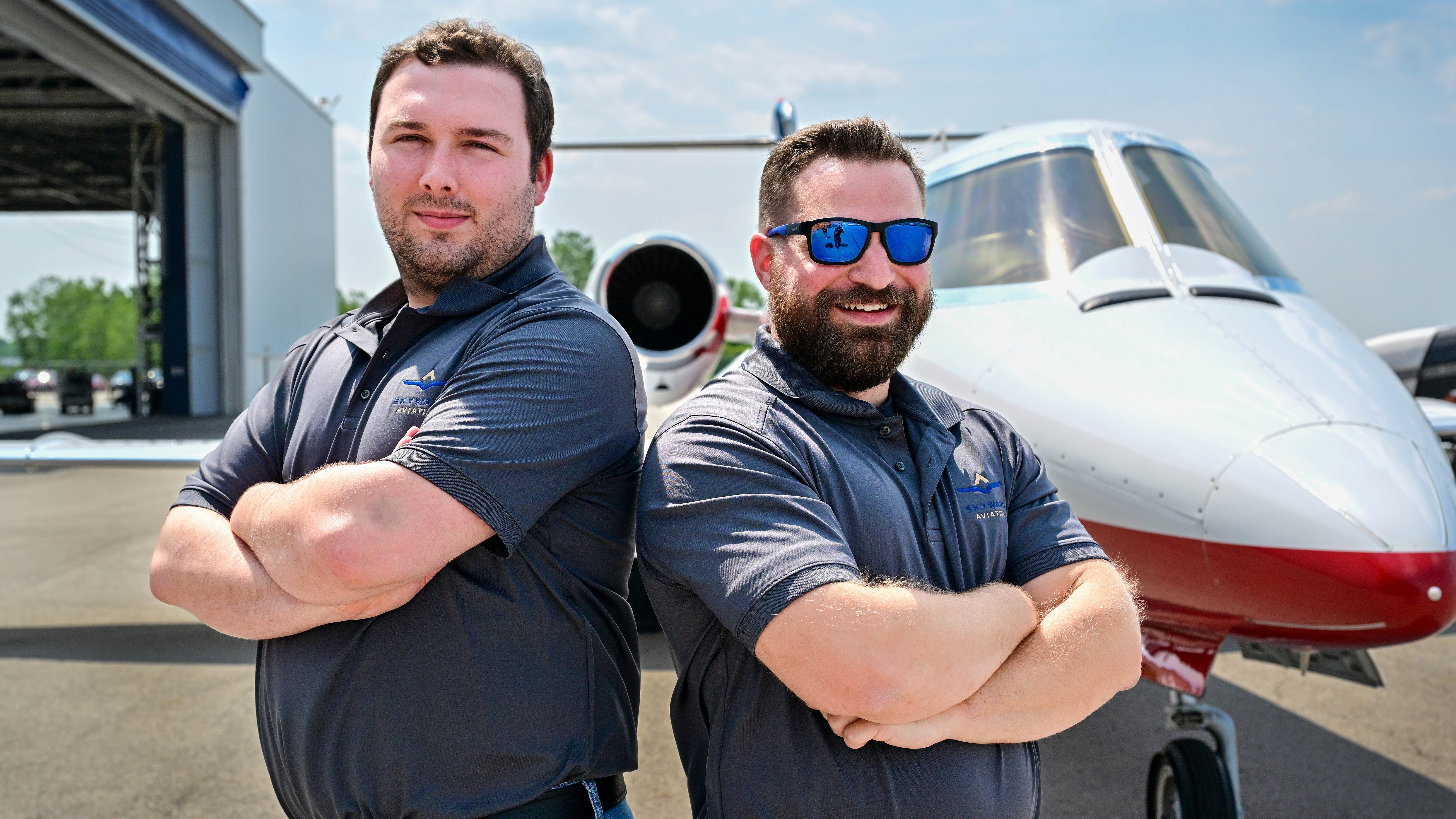 Pilots Jake Lewis (left) and Steve Casciola (right) near a patriotically painted Learjet 31A, one of three jets their company dedicates to organ transplant flights.