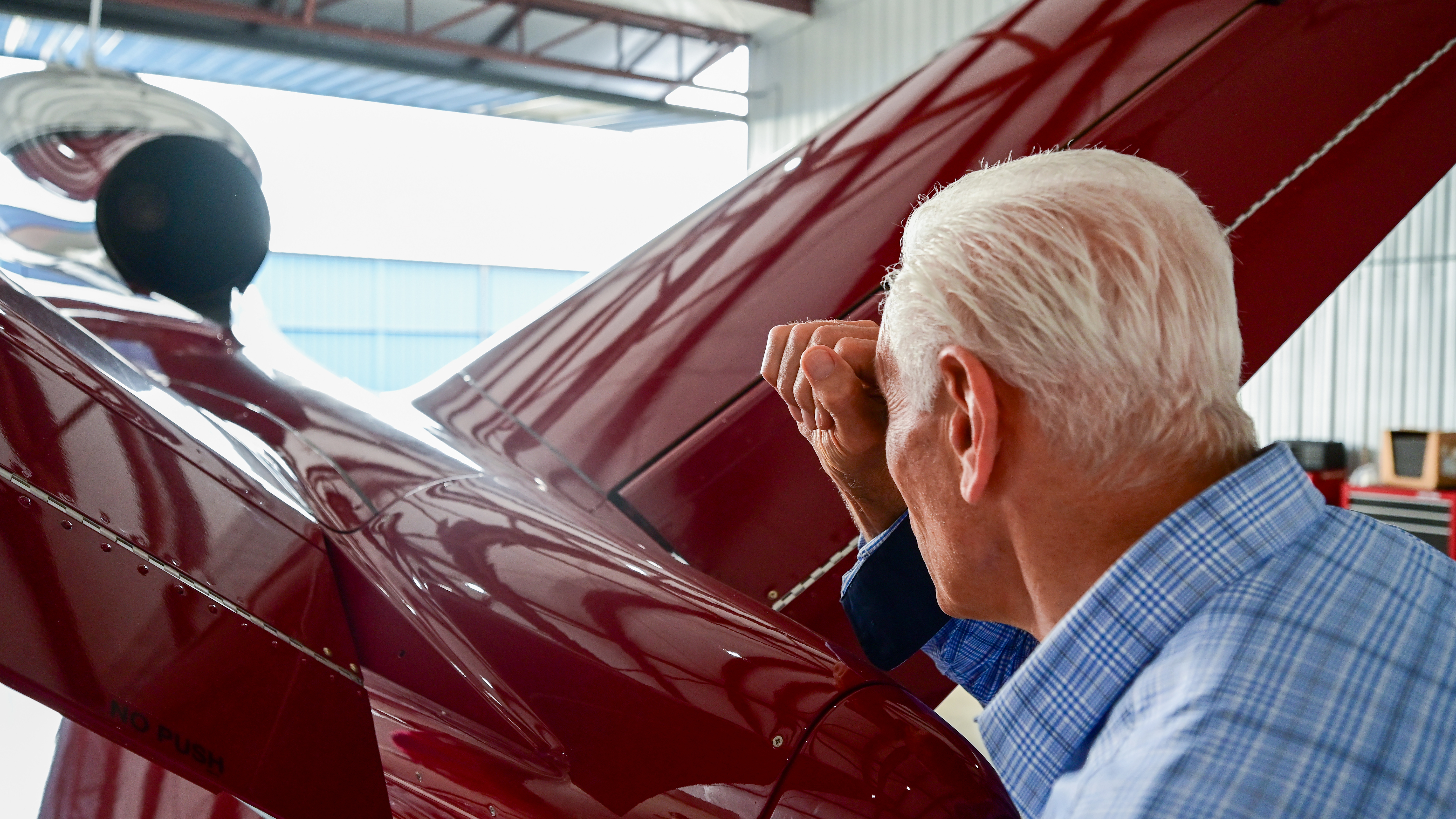 Masone looks through a closed fist to eliminate stray light while he visually inspects the jet engine during preflight. 