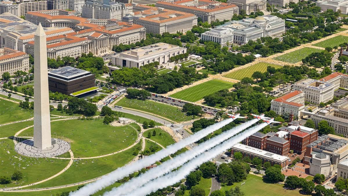 Smoke on: AOPA Director of Photography Chris Rose was in a Bell 407 helicopter provided by Zip Aviation, hovering on the edge of the Tidal Basin, and captured the photo of the Titan Aerobatic Team flying the finale.