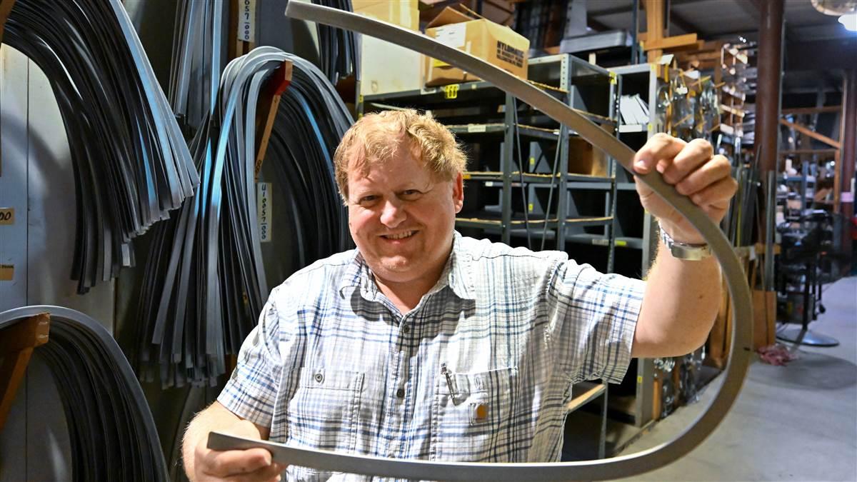 Jim Dyer holds a Piper J-3 window frame. Photography by David Tulis.