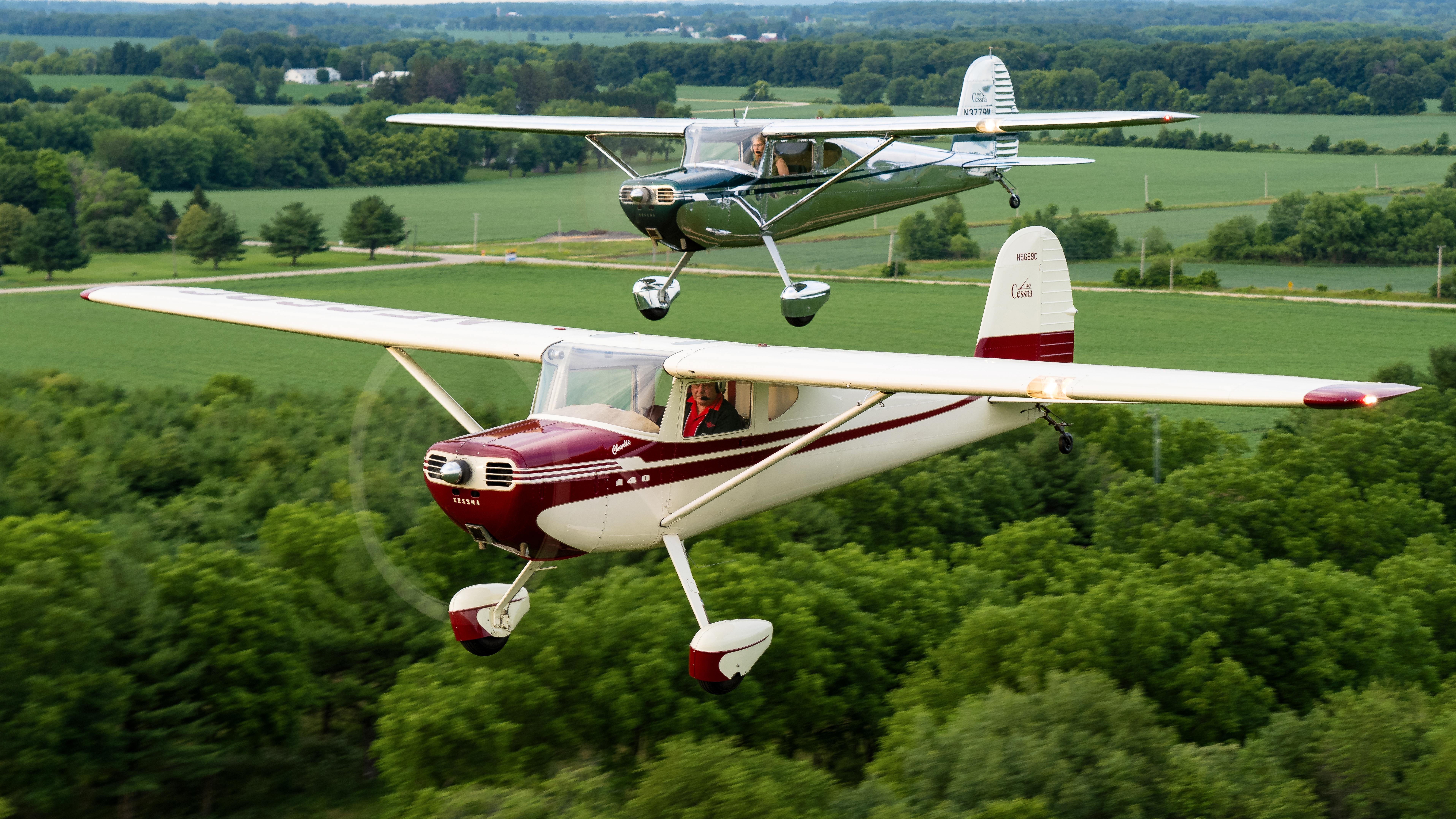 Ken, in Charlie, and Lorraine, in Uno, fly in formation near their hangar home and restoration shop in Poplar Grove, Illinois.
