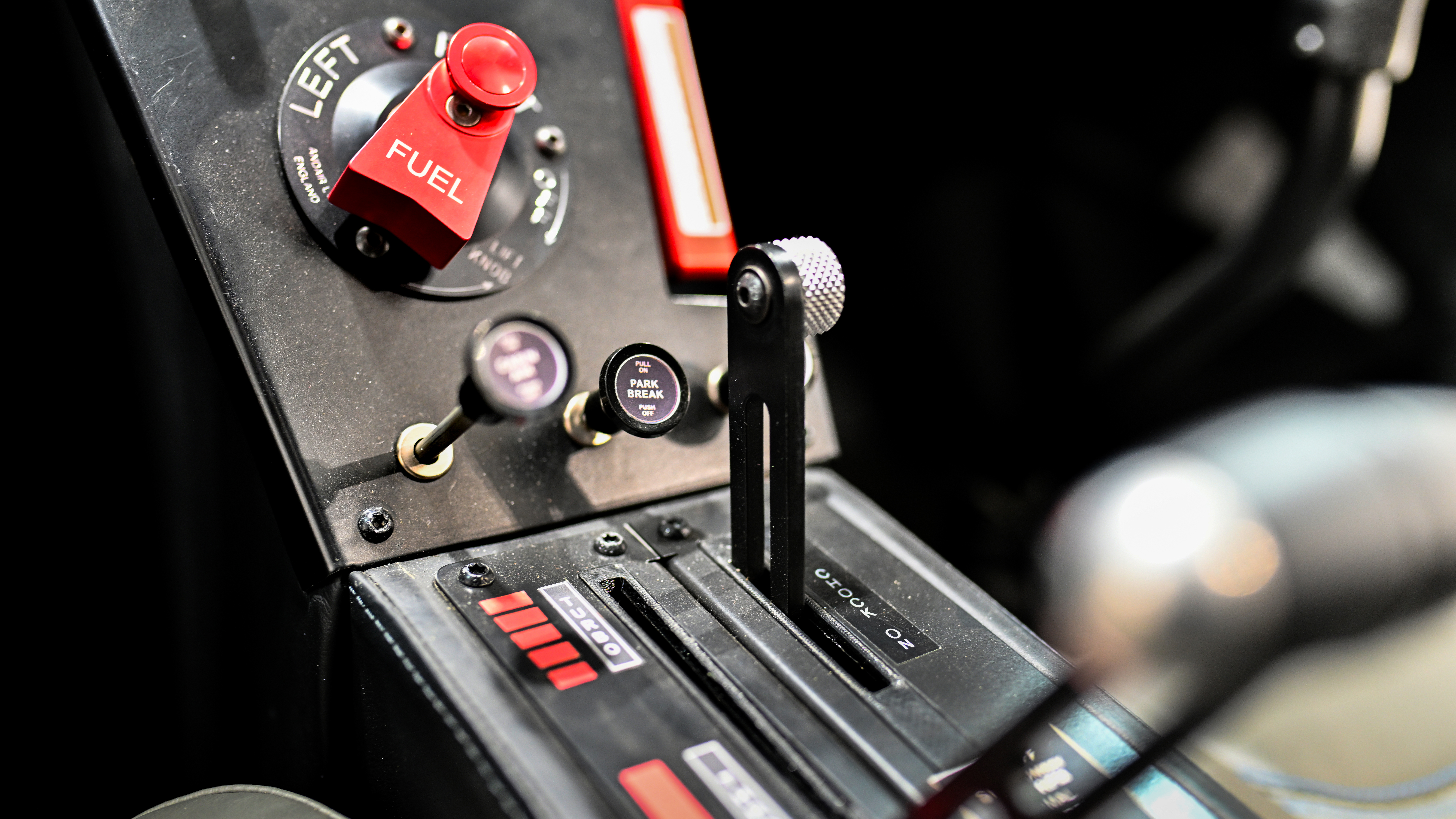 The fuel selector and airframe parachute handle are on the center console above the throttle and choke.