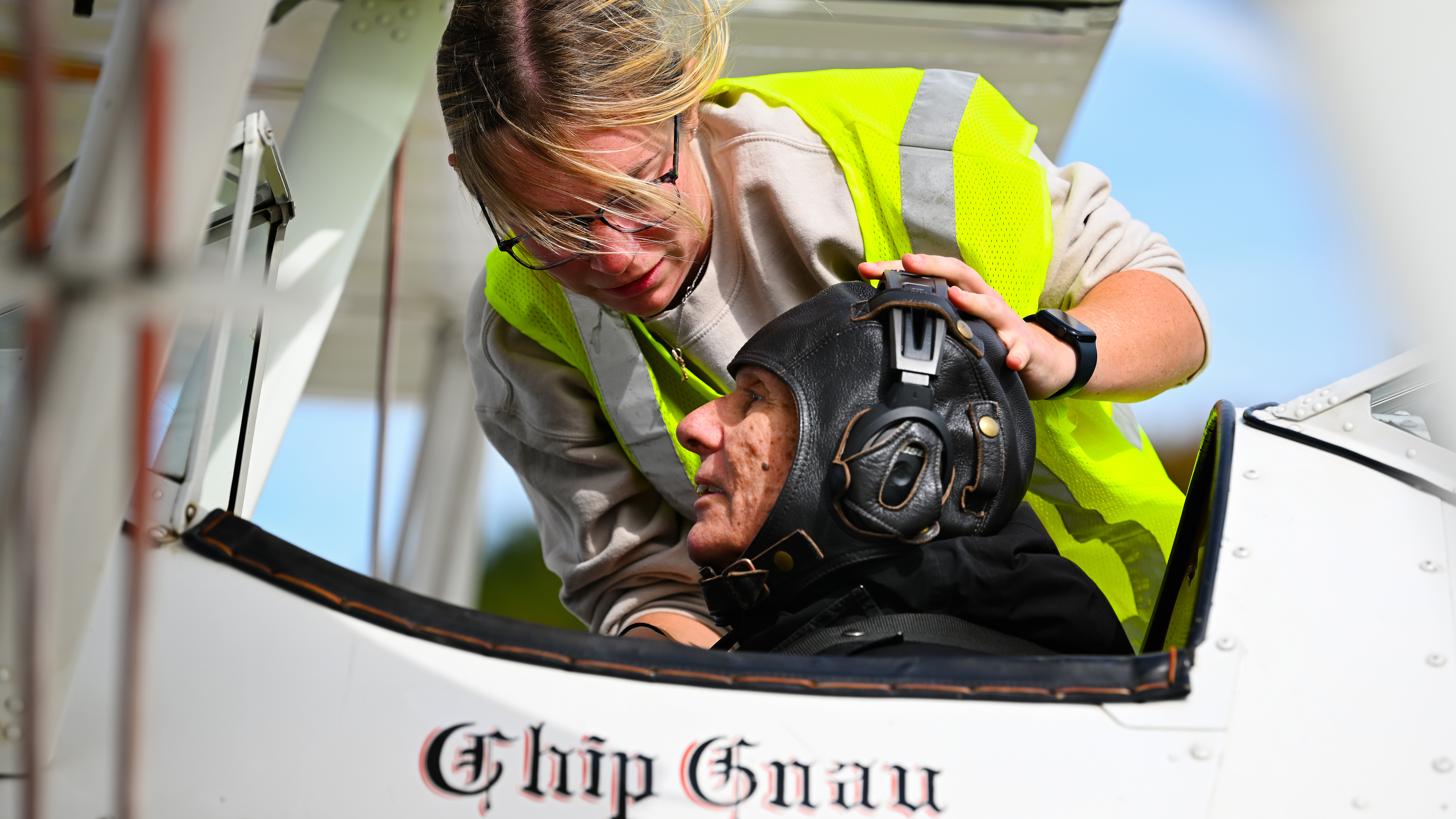Pilot and A&P Amy Gnau adjusts a headset on a ride participant.