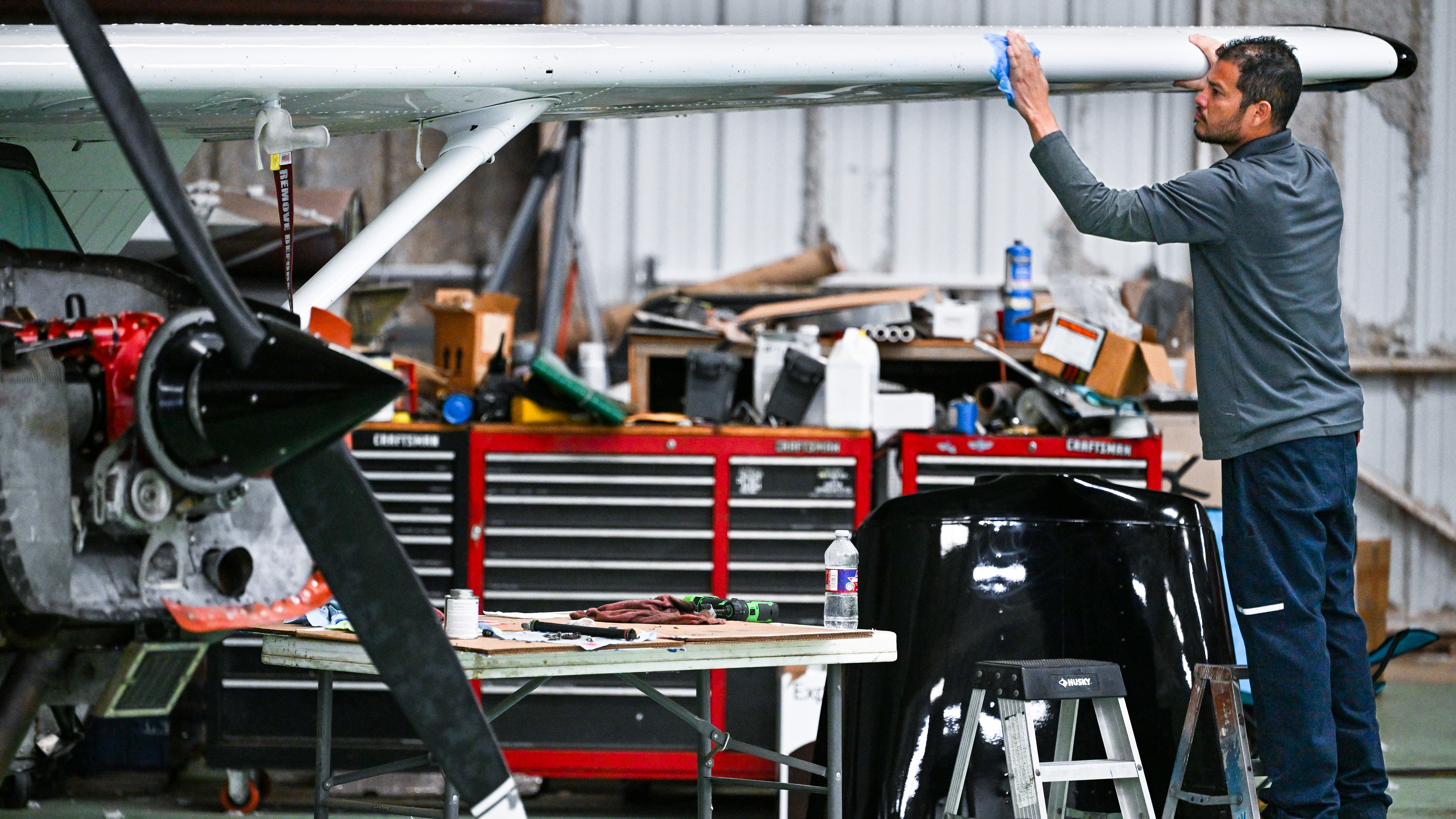 OBAP aviation maintenance trainee Carlos Zelaya cleans the leading edge of a freshly painted Cessna 172. Photo by David Tulis