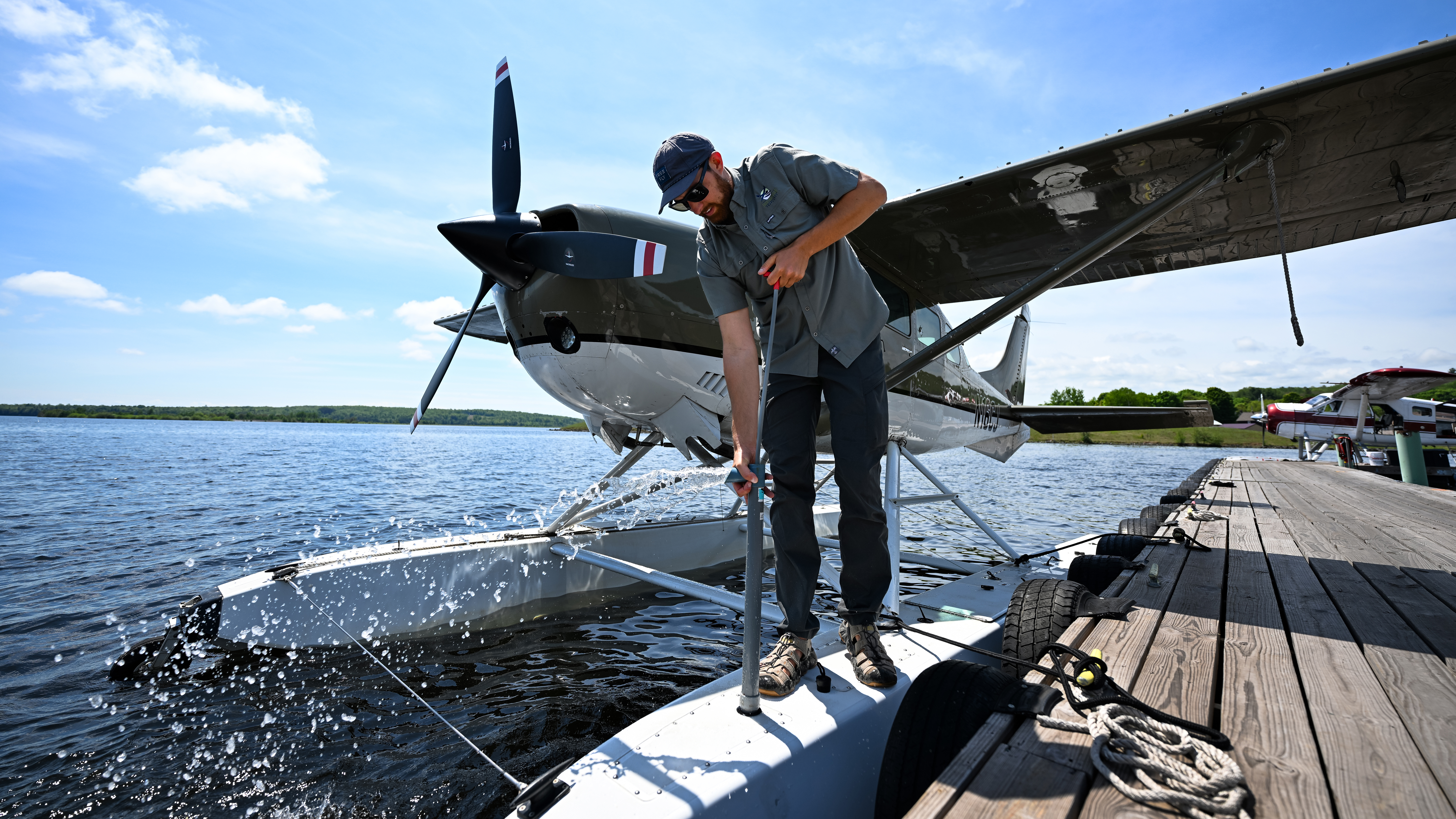 Seaplane pilot David Stawinski, pumping water from a Cessna 206 float, has extensive Alaska experience.