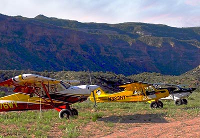 The Aircraft. Three Husky aircraft tied down in backcountry strip.