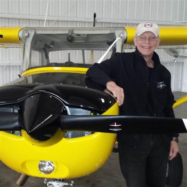 photo of pat brown next to a yellow cessna