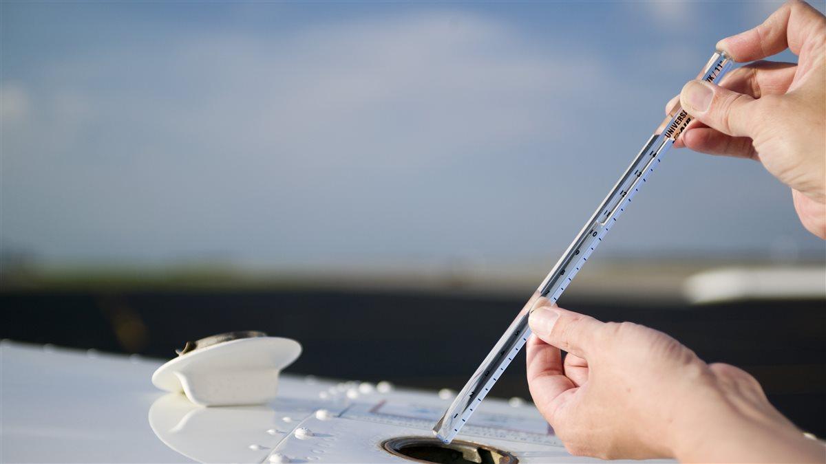 Photography of a pilot using a universal fuel gauge.Newton, KS   USA