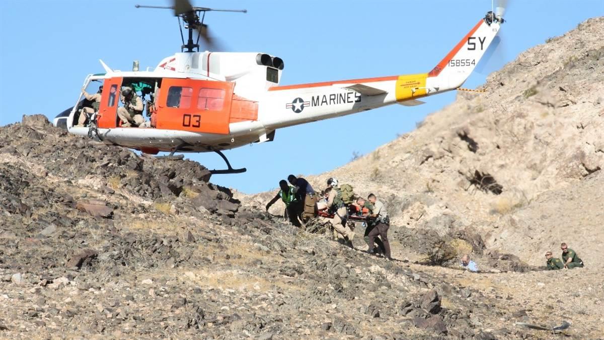 medevac team putting injured victim in their helicopter atop a mountain
