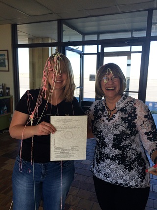 Stephanie Stechshulte (left) is dowsed with Silly String after successfully completing a private pilot checkride with designated pilot examiner Mary Latimer (right).