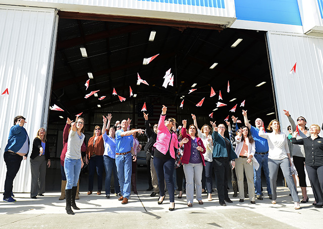 Thirty-four aviation enthusiasts who fashioned 397 pink paper airplanes in 15 minutes in an attempt to set a world record, launch their airplanes from AOPA's National Aviation Community Center in Frederick, Maryland, March 8. Photo by David Tulis.