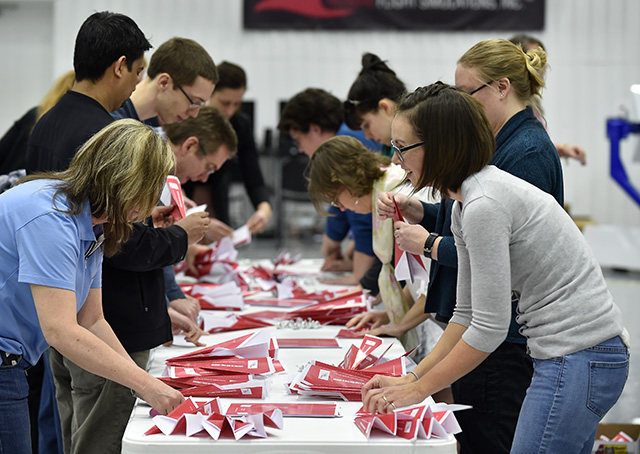 Thirty-four aviation enthusiasts including Karen Hemenway, right, helped fashion 397 pink paper airplanes in 15 minutes in an attempt to set a world record at AOPA's National Aviation Community Center in Frederick, Maryland. Photo by David Tulis.