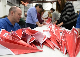 Flight instructor Chris Moser joins other pilots and aviation enthusiasts in a world record attempt at paper airplane construction. Photo by David Tulis.