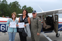Capt. Donnie Todd with teachers Romona Matin (right) and Kelly Roberson (left), holding their flight certificates upon landing.