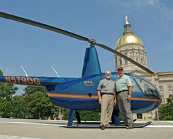 Perdue (right) with CFI Ron Carroll and a Robinson R44 in front of the Georgia capitol. Perdue earned his helicopter rating in 2008.