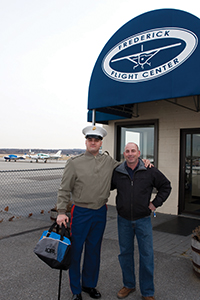 U.S. Marine Corps Sgt. Michael Blair stands with Dave Hirschman at the Frederick Municipal Airport.