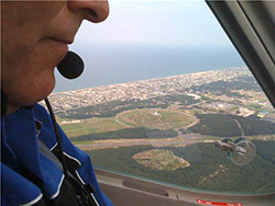Michael Combs, in the cockpit of the Remos GX, flies past the Wright Brothers National Memorial in Kill Devil Hills, N.C.
